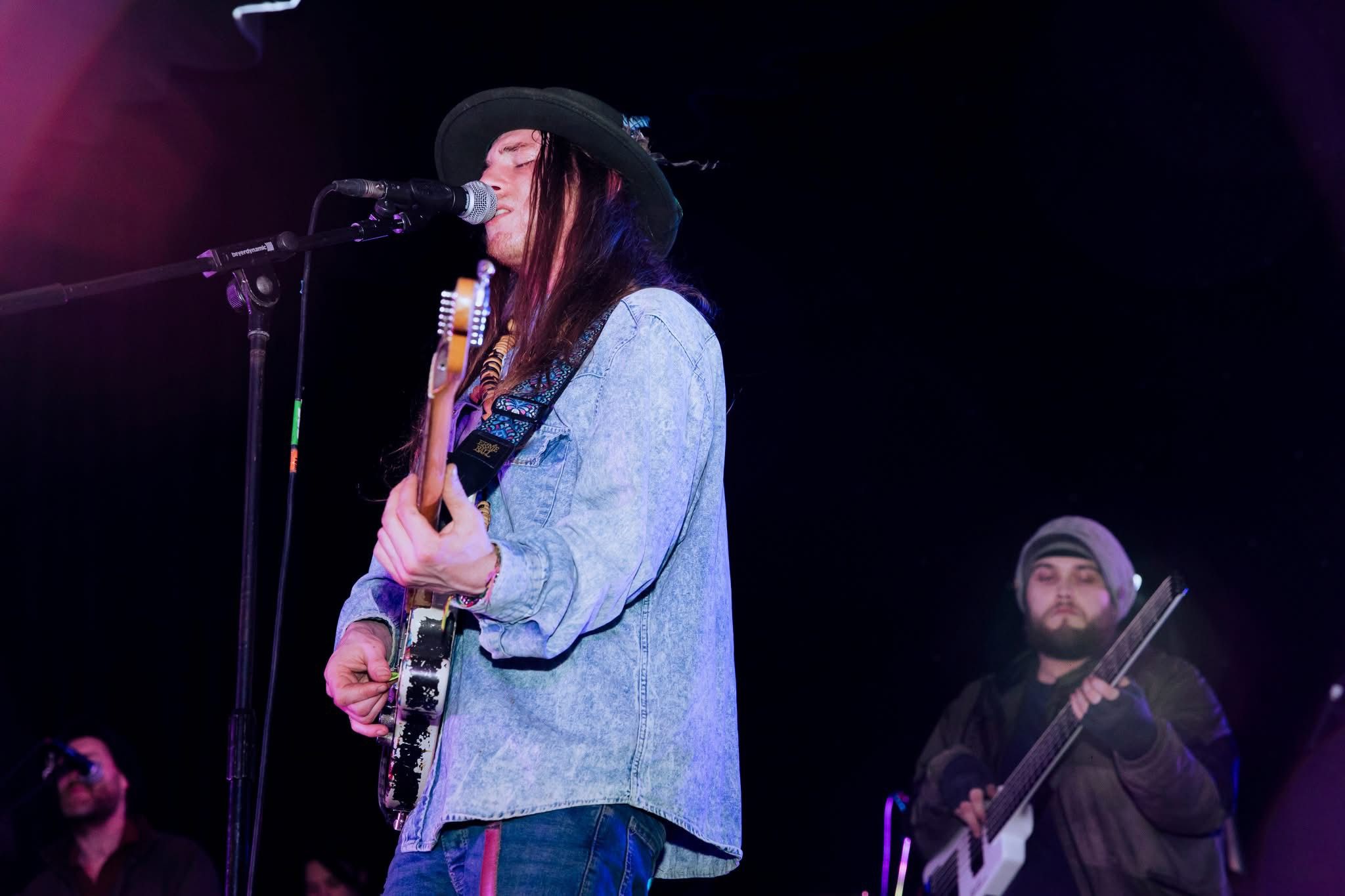 A musician singing and playing guitar on stage at the SRACA gala