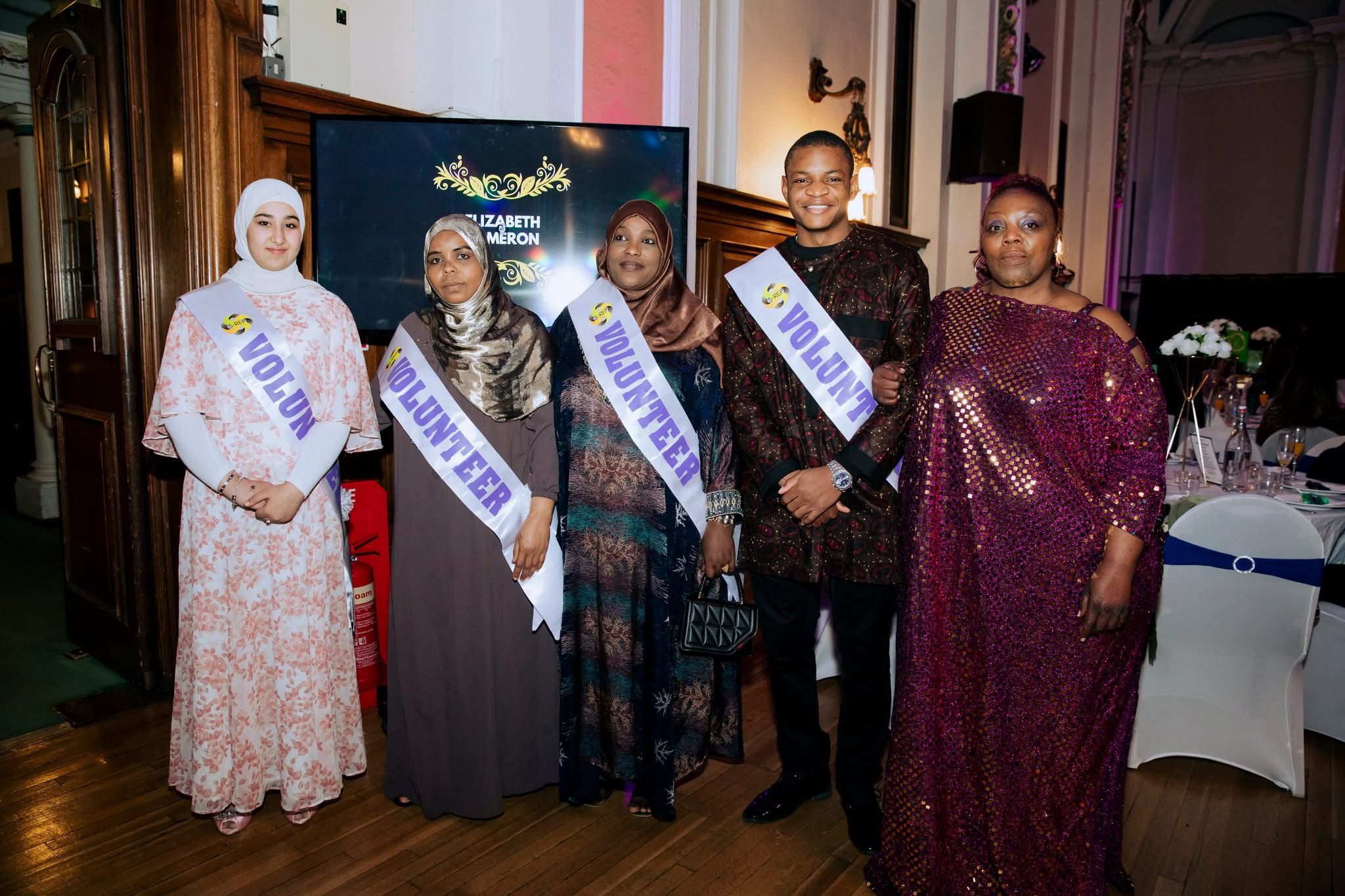 Five SRACA volunteers wearing sashes posing together at the gala