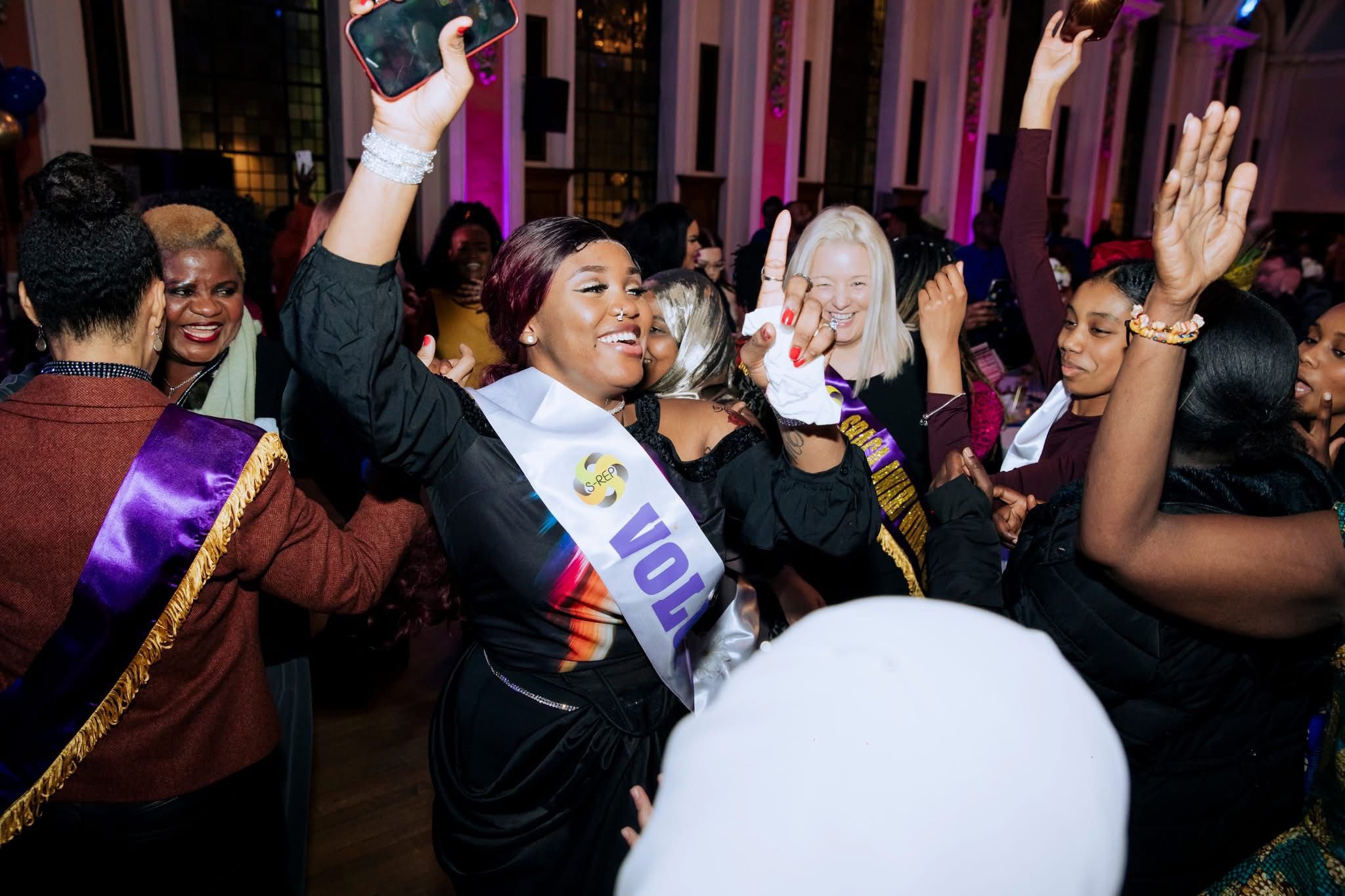 Guests cheering with hands raised on the dancefloor at the SRACA gala